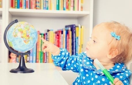 little girl pointing to a globe