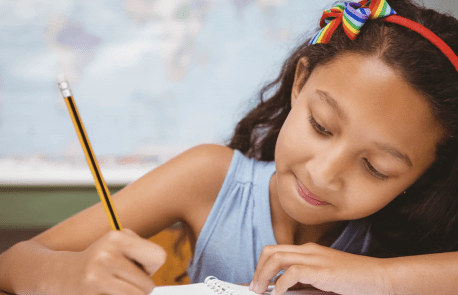 hispanic elementary student focusing on schoolwork